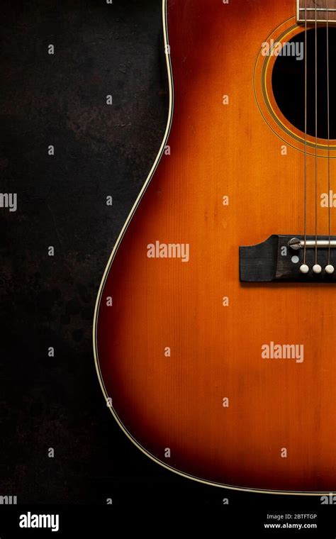 Acoustic guitar on dark brown background Stock Photo - Alamy