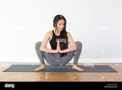 Beautiful woman doing a yoga pose called squat pose, or malasana pose Stock Photo - Alamy