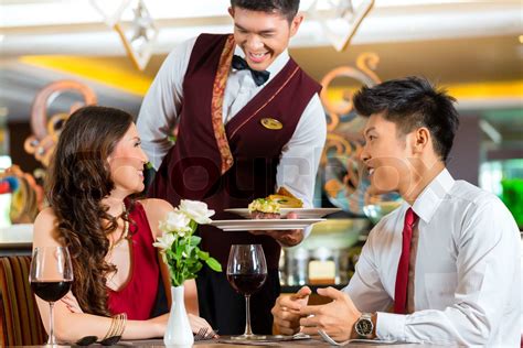 Chinese waiter serving dinner in elegant restaurant or Hotel | Stock image | Colourbox