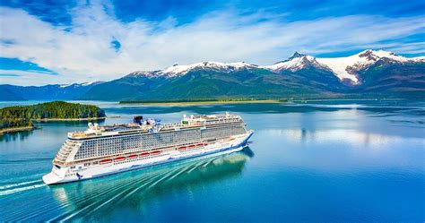 a cruise ship sailing in the ocean with mountains in the background