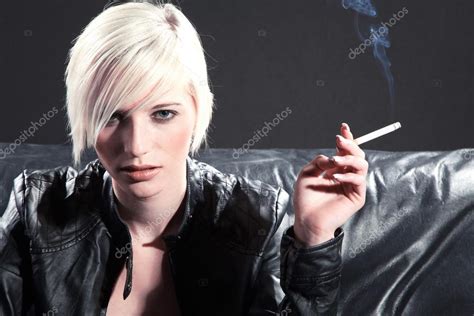 Blonde girl smoking a cigarette on a black couch Stock Photo by ©Nick_Freund 28458879