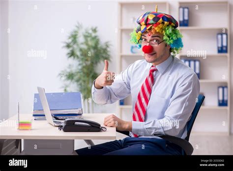 Funny employee clown working in the office room Stock Photo - Alamy