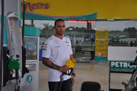 F1 driver Lewis Hamilton takes to pump duties at Petronas Dagangan ...