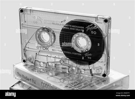 Monochrome image of the clear casing of a TDK compact cassette shows the intricate internal ...