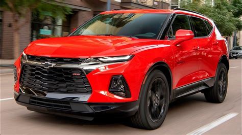 a red chevrolet suv driving down the street