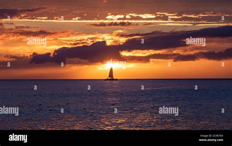 Scenic sunset viewed from Lahaina harbor, Maui, Hawaii. A silhouette of sail boat against ...