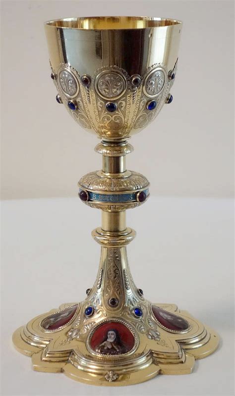 an ornately decorated gold chalice with blue and red stones on the ...