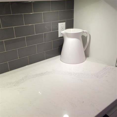 Caesarstone Calacatta Nuvo countertops with shiny gray glass subway tiles | Caesarstone ...