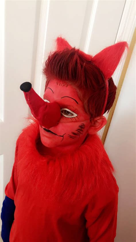 a person wearing a red fox costume standing in front of a door