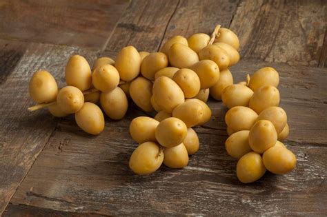 Premium Photo | Bunch of fresh yellow dates on the table