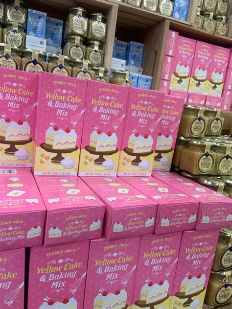 boxes of yellow cake and baking mix are stacked on display in a grocery store aisle