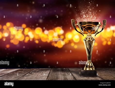 Champion golden trophy on wood table with blur spot lights on background. Copyspace for text ...