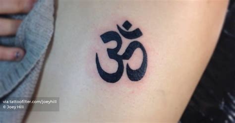 Om symbol tattooed on the upper arm.