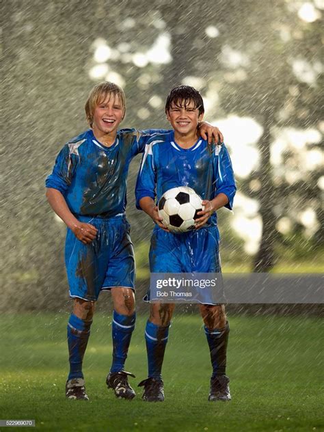 Two boys stand in the rain after a soccer match. | Soccer players ...