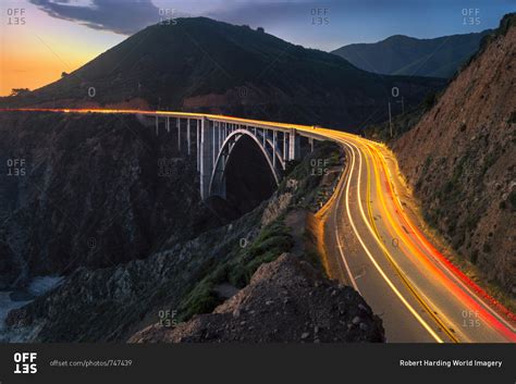 Sunset over Bixby Creek Bridge and car trail lights, Big Sur, California, United States of ...