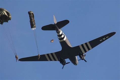 Paratroopers exit a Douglas DC-3 C-47 Dakota Skytrain for a commorative jump over the D-day ...