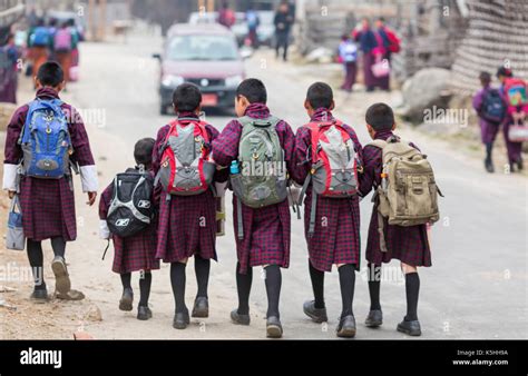 Schoolchildren on their way to the town school wearing traditional ...