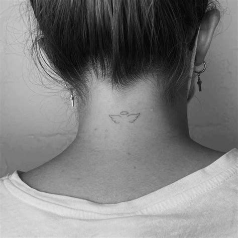 Minimalistic angel wings and halo tattoo located on the