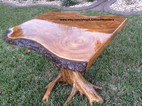 a wooden table sitting on top of a green grass covered park field next ...