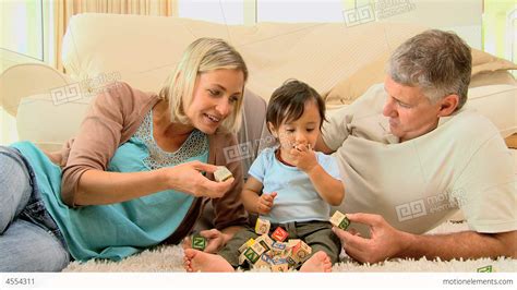 Doting Parents Laughing With Baby On Carpet Stock video footage | 4554311