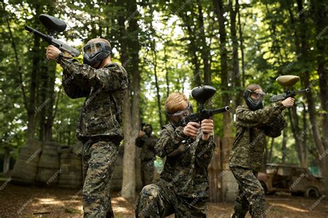 Premium Photo | Soldiers in camouflage and masks playing paintball in ...