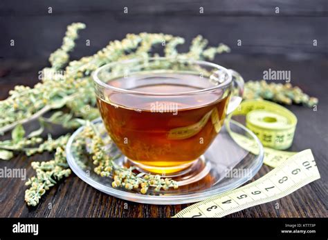 Tea with wormwood in glass cup and meter on dark board Stock Photo - Alamy