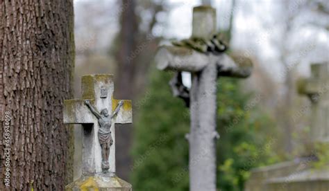 Old crosses in a Catholic cemetery. Stone crosses covered with moss. Jesus on the cross. Blurry ...