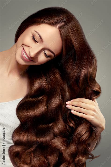 Hair. Beautiful girl with long wavy and shiny hair. Brunette woman with gorgeous curly hairstyle ...