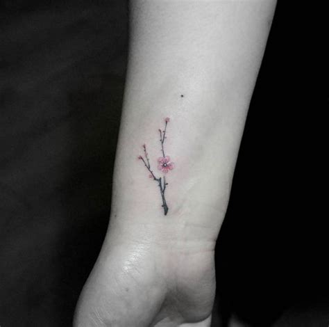 Tiny cherry blossom tattoo on wrist by Tattoo With Me | Trendy tattoos, Blossom tattoo, Tattoos