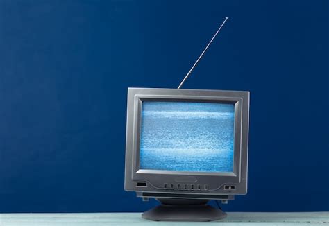 Premium Photo | Tv shop. antenna old-fashioned retro tv with mini supermarket trolley on white wall