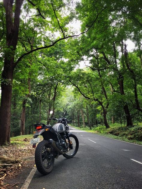 a motorcycle is parked on the side of the road near some trees and ...