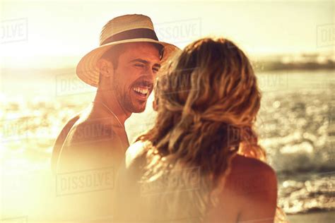 Laughing young couple on sunny summer beach - Stock Photo - Dissolve