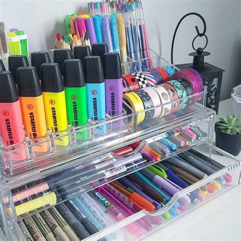 a clear plastic drawer filled with lots of pens and markers