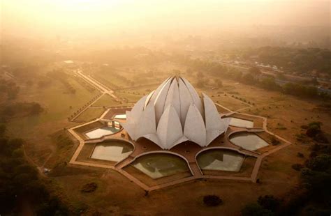 The Lotus Temple dotted with pigeons at sunrise. Designed by an Iranian ...