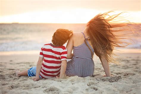 "Boy And Girl Sitting At The Beach At Sunset" by Stocksy Contributor "Angela Lumsden" - Stocksy