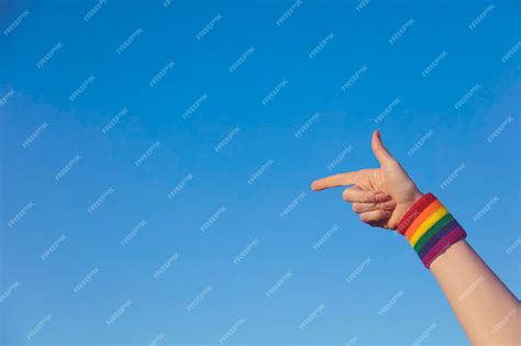 Premium Photo | Gay pride concept pointing hand with gay pride lgbt rainbow flag wristband