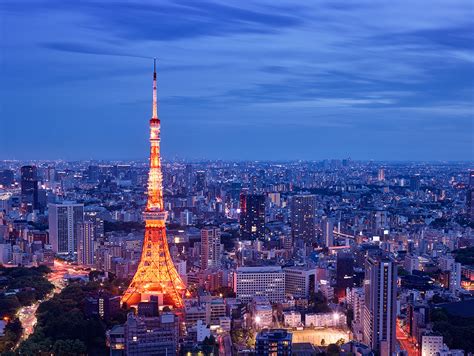 tokyo tower at dusk night lights blue sky city below from above long exposure lights orange ...