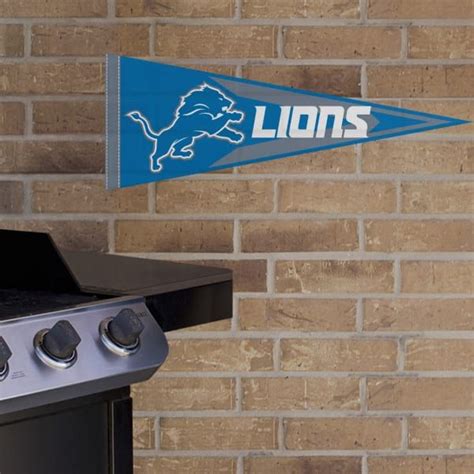 a detroit lions pennant hanging from the side of a brick wall next to an oven