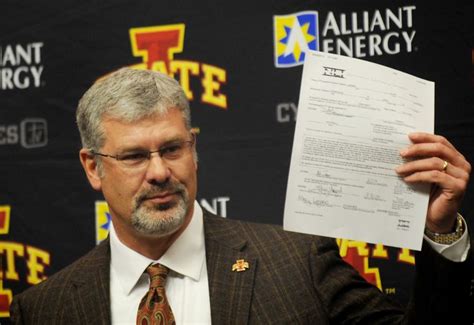 Iowa State football coach Paul Rhoads holds up the national letter of ...