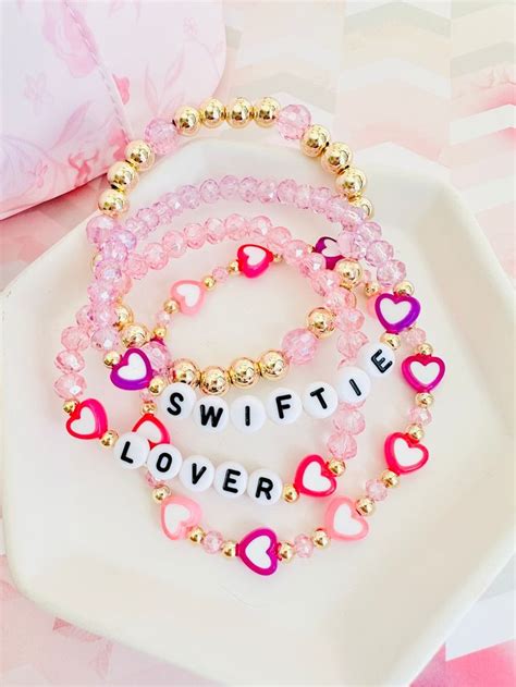 three bracelets that say swiffie, love and heart beads on a plate