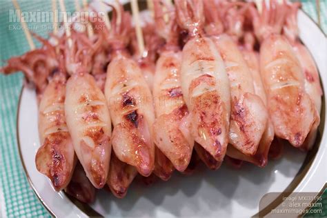 Photo of Ikayaki grilled squid skewers Japanese street food at a market stall | Stock Image MXI31195