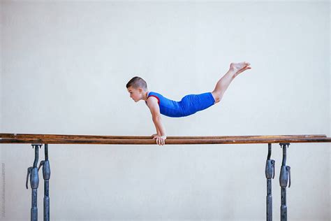 "Gymnastics, Young Boy Practicing On Parallel Bars" by Stocksy Contributor "Mihajlo Ckovric ...