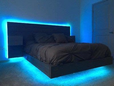 a bed with blue lights on the side and a black headboard in the middle