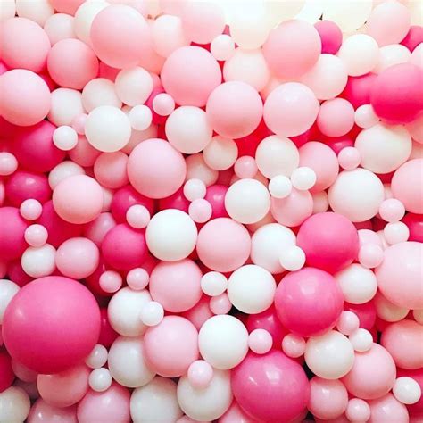 pink and white balloons floating in the air