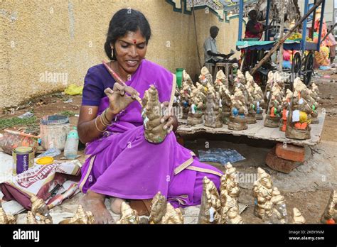Tamil woman painting small clay idols of Lord Ganesha (Lord Ganesh) at ...