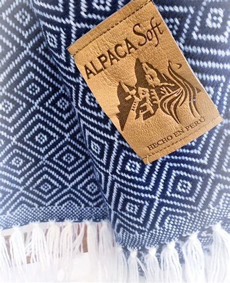 a blue and white blanket with a tag on it that says alpaca soft