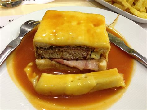 Francesinha: a Portuguese sandwich made with bread, ham, linguica (smoked pork sausage), and ...