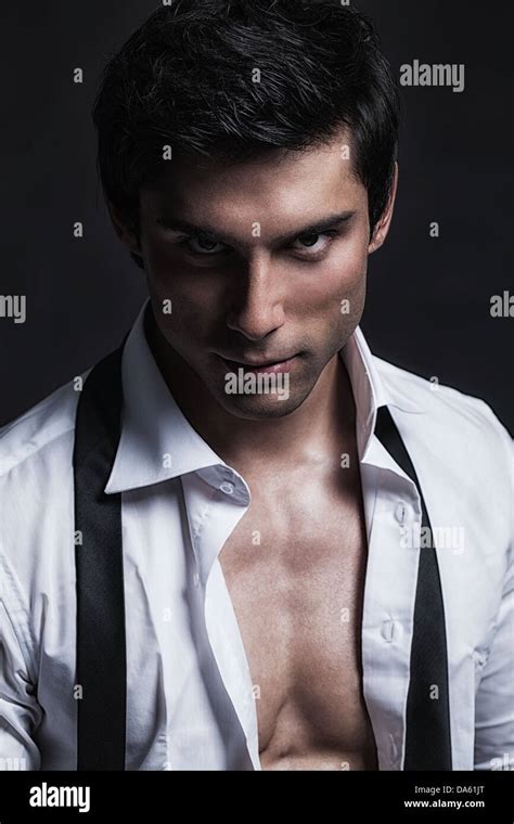 A handsome male model posing at a studio in front of a black background Stock Photo - Alamy