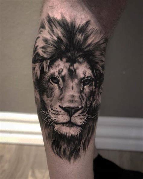 Black and grey lion tattoo on the calf.