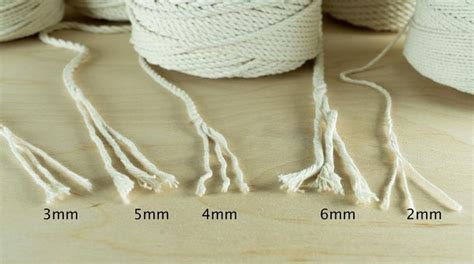 three spools of white twine sitting on top of a table next to each other